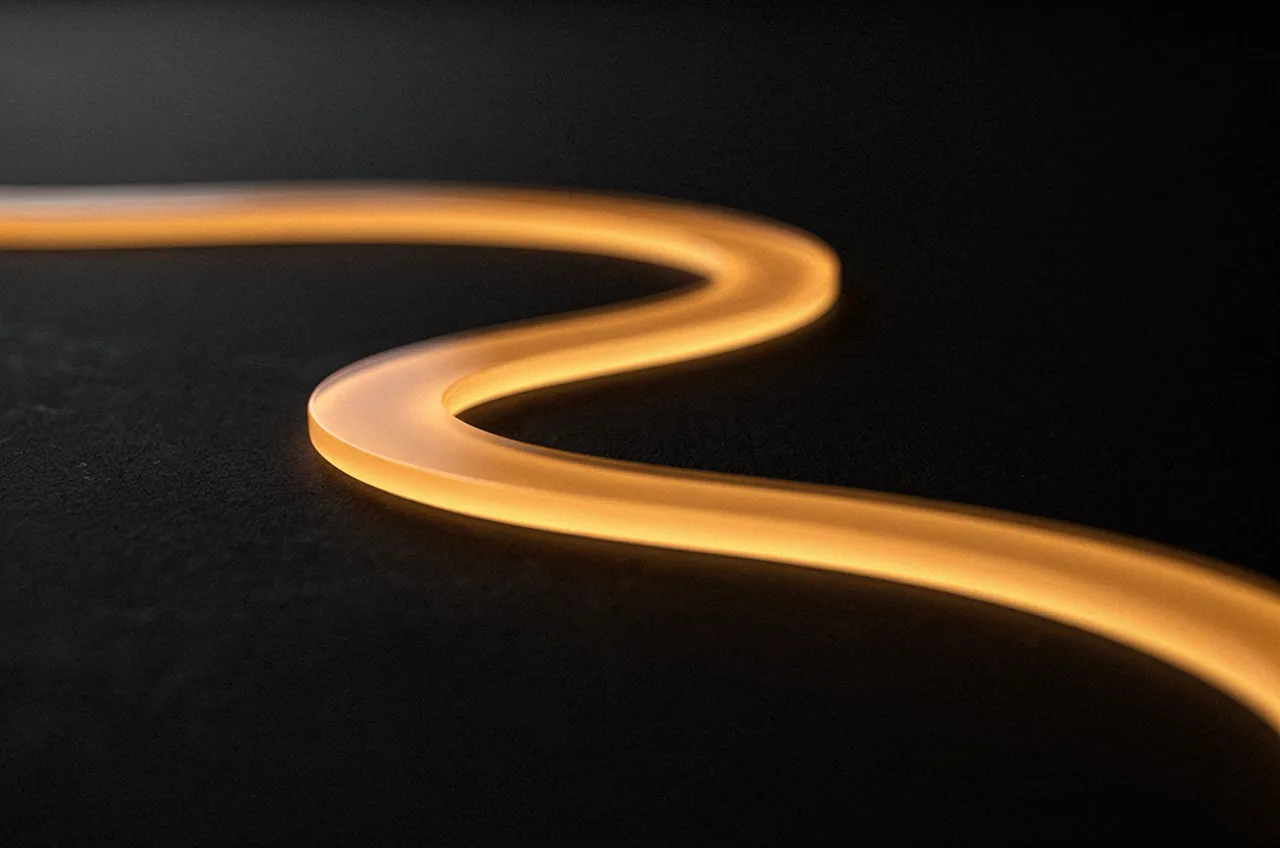 A luminous amber path that flows forward then reverses on itself against darkness — an inverted expectation.